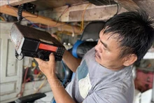 富安坊渔民出海前检查航程监控设备。（图片来源：越通社）