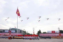 人民空军直升机编队悬挂党旗与国旗飞越河内上空。