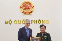 黄春战上将向联合国副秘书长让-皮埃尔·拉克鲁瓦赠送纪念品。(图片来源:qdnd.vn)
