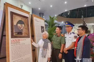 昆岛前政治囚犯黎秀锦观看年轻时期的肖像画。（图自qdnd.vn）