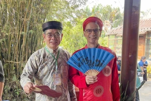 外国外交官体验越南传统奥黛与头巾。（图片来源：越通社）