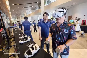 与会代表在论坛发布会上体验服务于旅游业的虚拟现实技术。（图片来源：越通社）