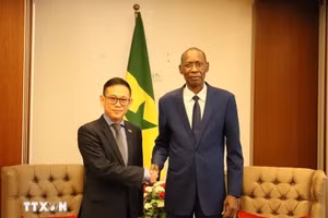 塞内加尔非洲一体化、外交和海外侨民事务部部长谢赫·尼昂与越南驻阿尔及利亚大使兼驻塞内加尔大使陈国庆亲切握手。（图片来源：越通社）