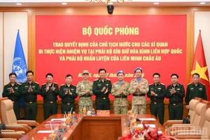 阮长胜上将与两名参加维和任务的军官和各位代表合影。