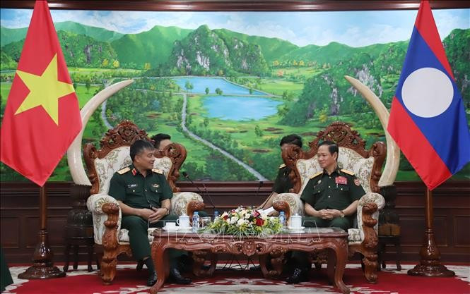 越南国防部副部长阮文贤中将礼节性拜会老挝国防部长坎良·奥萨宋。（图片来源：越通社）
