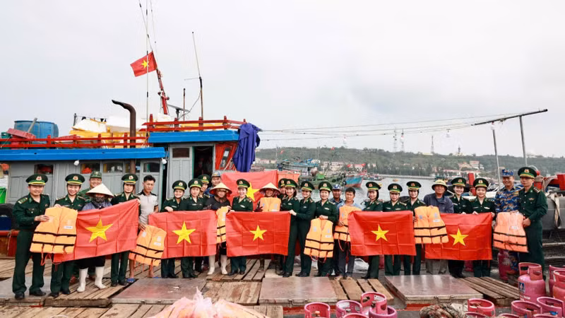 海防市边防部队和海警向渔民赠送国旗、救生衣和进行法律宣传。（耀玉 摄）