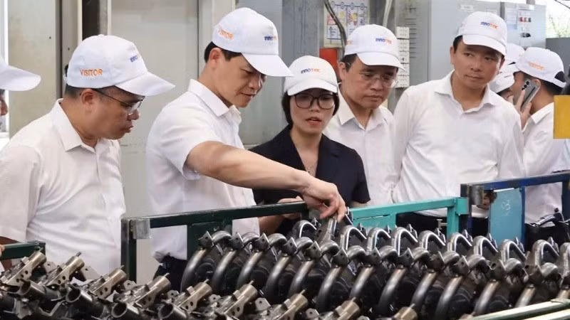 资料图：北宁省人民委员会主席王国俊（左二）参观Innotek股份公司的生产模式。