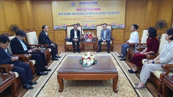 12月8日晚，老挝记者协会主席沙万坤·拉沙蒙迪率团来访越南新闻工作者协会并进行了座谈交流。（图片来源：越通社）