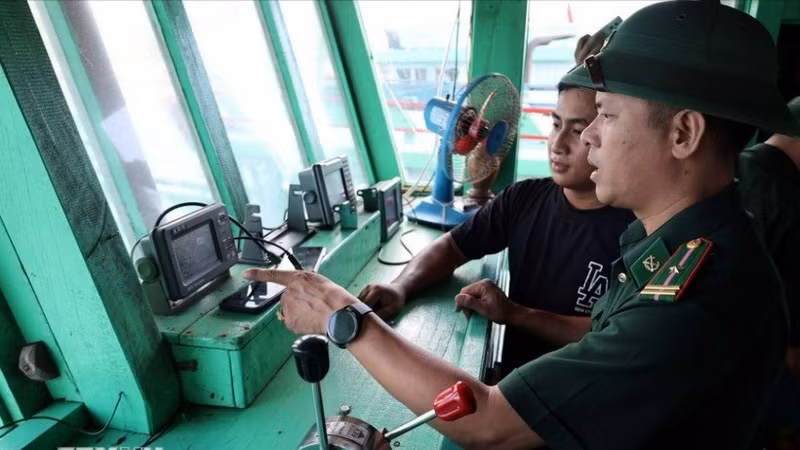 岘港市边防部队指挥部山茶边防站的干部、战士对渔民的渔船通信联络设备进行检查。（图片来源：越通社）