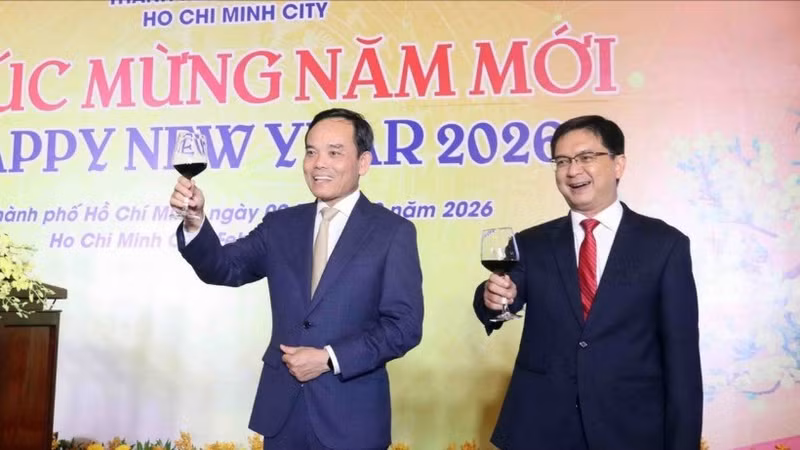 越共中央政治局委员、胡志明市市委书记陈流光（左）与出席活动的来宾举杯共庆新年。（图片来源：越通社）