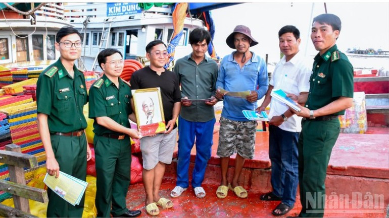 芹苴市边防部队指挥部向渔民赠送国旗和胡伯伯的照片。（图片来源：越通社）