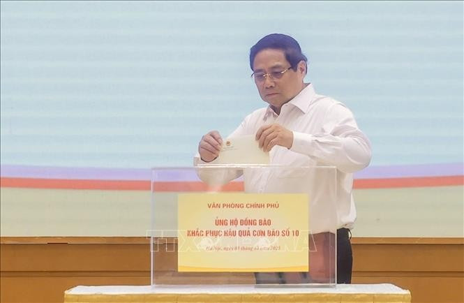 政府总理范明正为遭受第十号台风影响的灾民捐款。（图片来源：越通社）