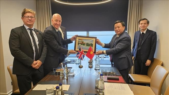 胡志明国家政治学院院长、中央理论委员会主席阮春胜向越英友好网络主席、前英国驻越大使马克·肯特送礼。（图片来源：越通社）
