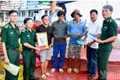 芹苴市边防部队指挥部向渔民赠送国旗和胡伯伯的照片。（图片来源：越通社）