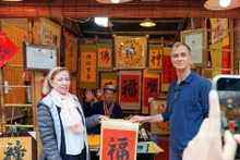 国际游客体验年初“求字”活动。（图片来源：越通社）