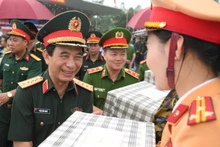国防部部长潘文江大将在综合演练上向参加阅兵、游行的各方力量赠送纪念品。