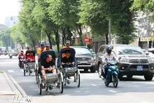 游客乘坐人力三轮车参观胡志明市中心。（图片来源：越通社）