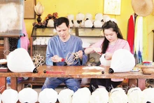 华南服务有限责任公司董事长武廷黄与其“璀璨发牌唱曲”灯笼系列产品合影。