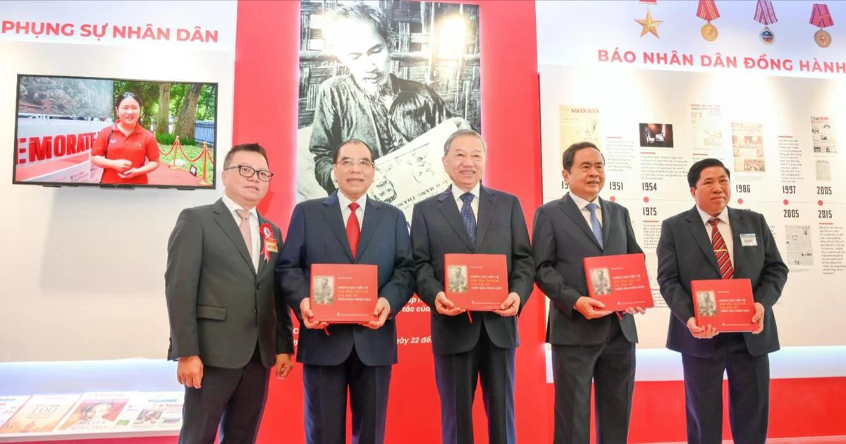 越共中央总书记苏林与党和国家领导同志及代表们在《人民报》社展区获赠《胡志明主席在〈人民报〉上发表的关于文化与新闻的文章选编》一书。