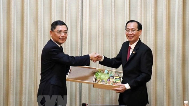 胡志明市人民委员会常务副主席黎清廉（右）向上海市人民政府副市长彭沉雷赠送礼品。（图片来源：越通社）