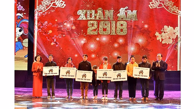 张氏梅，黄忠海同志在晚会上向贫困者转送慰问品。