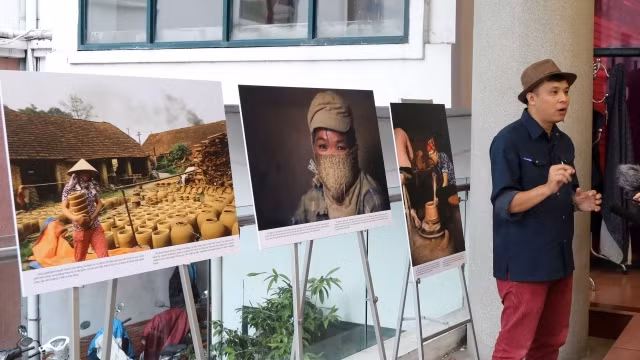 黎碧摄影记者向观众介绍他的作品。（图片来源：人民报网）