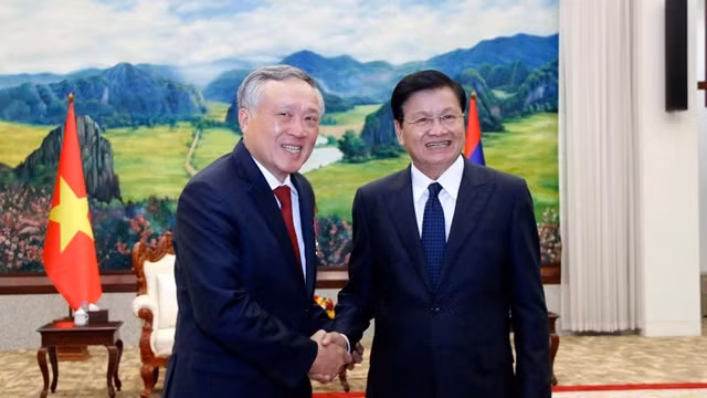 越南最高人民法院院长阮和平与老挝人民革命党中央委员会总书记、国家主席通伦•西苏里握手。