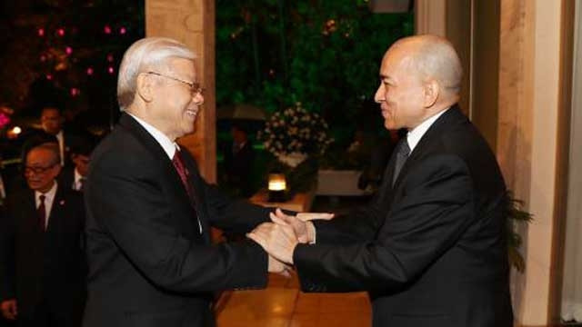 越共中央总书记阮富仲同柬埔寨国王诺罗敦·西哈莫尼亲切握手。