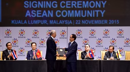 马来西亚总理纳吉布向东盟秘书长黎良明移交有关成立东盟共同体的文件。（图片来源：VGP）