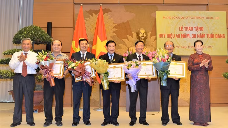 国会主席阮氏金银向党员们授予40年、30年党龄章。（图片来源：国会门户网站）