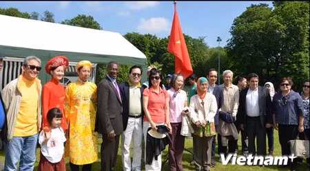 各位大使及夫人在越南展位前合影。（图片来源：越通社）