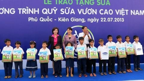 阮氏金银副主席向富国岛贫困儿童赠送牛奶。 (Photo: 图片来源：人民报网)