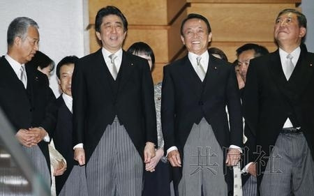 日本首相安倍晋三新改组内阁首次会议后准备合影。图片来源：日本共同社