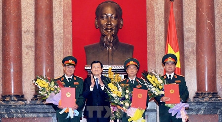 张晋创主席向三位中将颁发晋升上将军衔的决定。（图片来源：越通社）