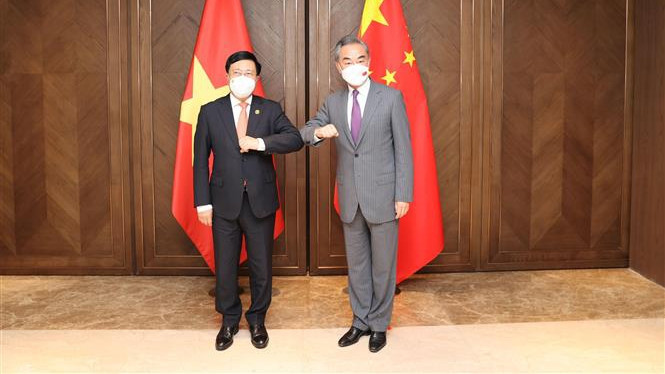 越共中央政治局委员、政府常务副总理范平明（左）与中国国务委员兼外交部长王毅合影。（图片来源：越通社）