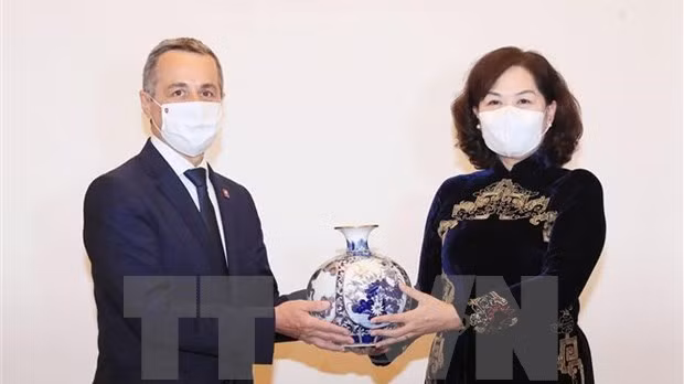 越南国家银行行长阮氏红向瑞士联邦副主席兼外交部部长伊格纳齐奥·卡西斯赠送纪念品。