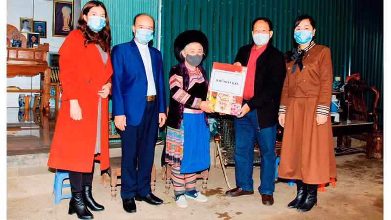 《人民报》社驻老街省代表向老街市北强坊赫蒙族越南英雄母亲李塞赛赠送春节礼物。