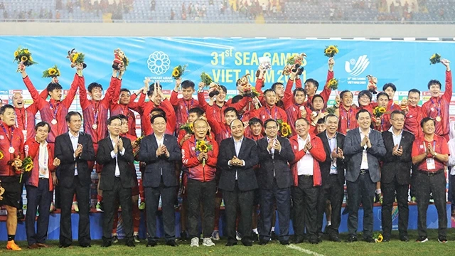 国家主席阮春福，政府总理范明正，国会主席王廷惠，越共中央书记处常务书记武文赏与越南U23足球队合影。（啸明 摄）