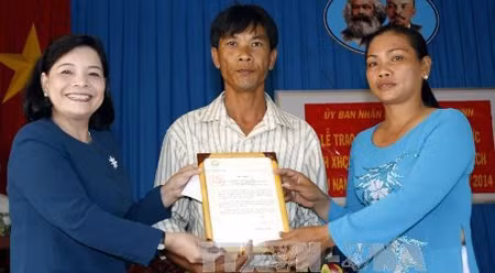 胡志明市竞赛奖励委员会主任阮氏如水向陈文有先生颁发国家主席的表扬信。（图片来源：越通社）