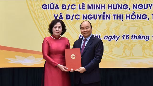 政府总理阮春福向阮氏红颁发国家银行行长任命书。（陈海 摄）