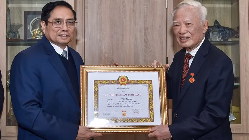 政府总理范明正向前政府副总理武宽授予60年党龄纪念章。