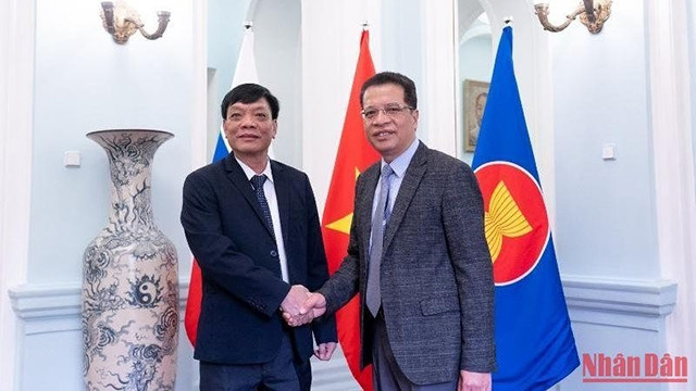 邓明魁大使与吴明进上将握手。