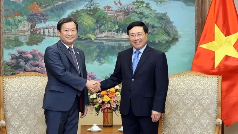 越南政府常务副总理范平明（右）与日本国际协力机构高级副总裁山田顺一。（图片来源：VGP）