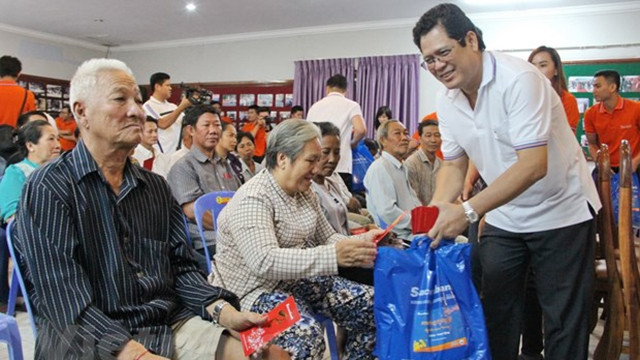 越南西贡商信股份商业银行副总经理黎文仁向正在柬埔寨居住的越裔柬埔寨人赠送礼物。（图片来源：越通社）