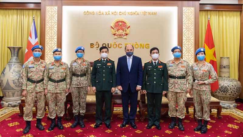 越南国防部长潘文江和英国国防大臣罗伯特•本•洛班•华莱士同越南维和局官兵合影。