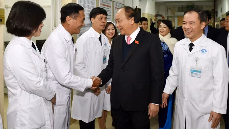 阮春福总理与中央眼科医院医务人员交谈。
