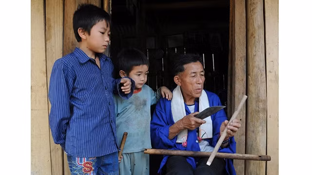 胡茶靠先生向子孙后代介绍竹笛制作方法。（图片来源：陈海 摄）