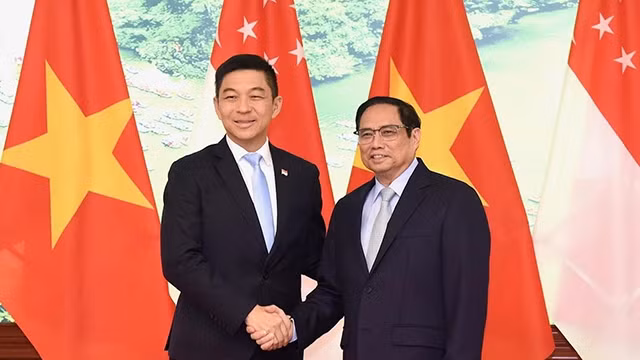 范明正总理与新加坡国会议长陈川仁握手。