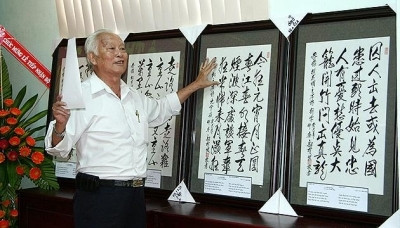 书法家乌民发与他的作品。 (Photo: 图片来源：人民报网)