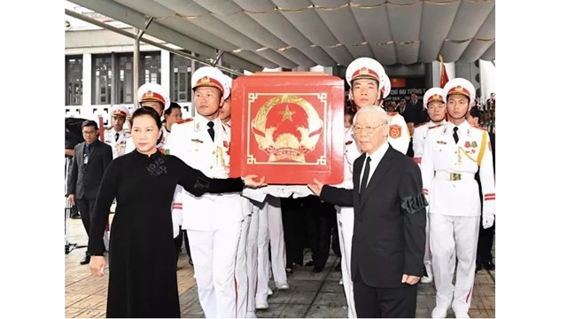 阮富仲总书记、国会主席阮氏金银及党和国家其他领导护送灵柩上灵车。（维灵 摄）